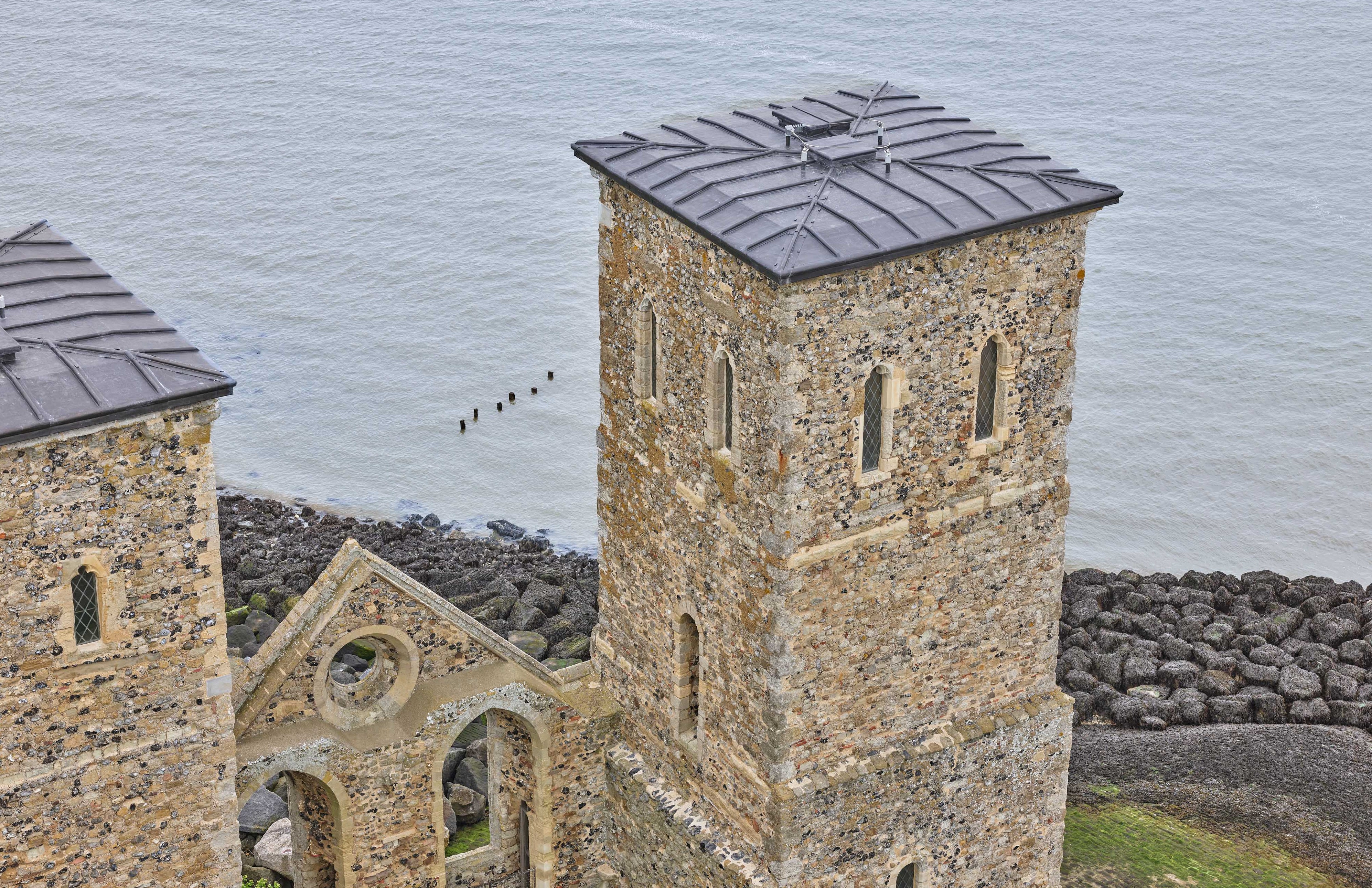 Close-up aerial photo of one of the towers at Reculver Towers and Roman Fort with the sea in the background