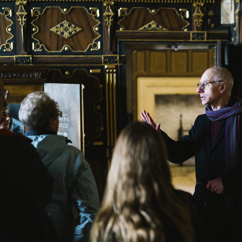 Photo of a guide speaking to a group of visitors in a wooden-panelled room at Bolsover Castle