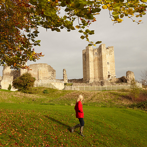 Image: a woman walks in front of Conisbrough Castle